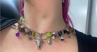 a woman wearing a necklace with a lot of charms on it