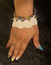 a woman's hand with a colorful bracelet on it